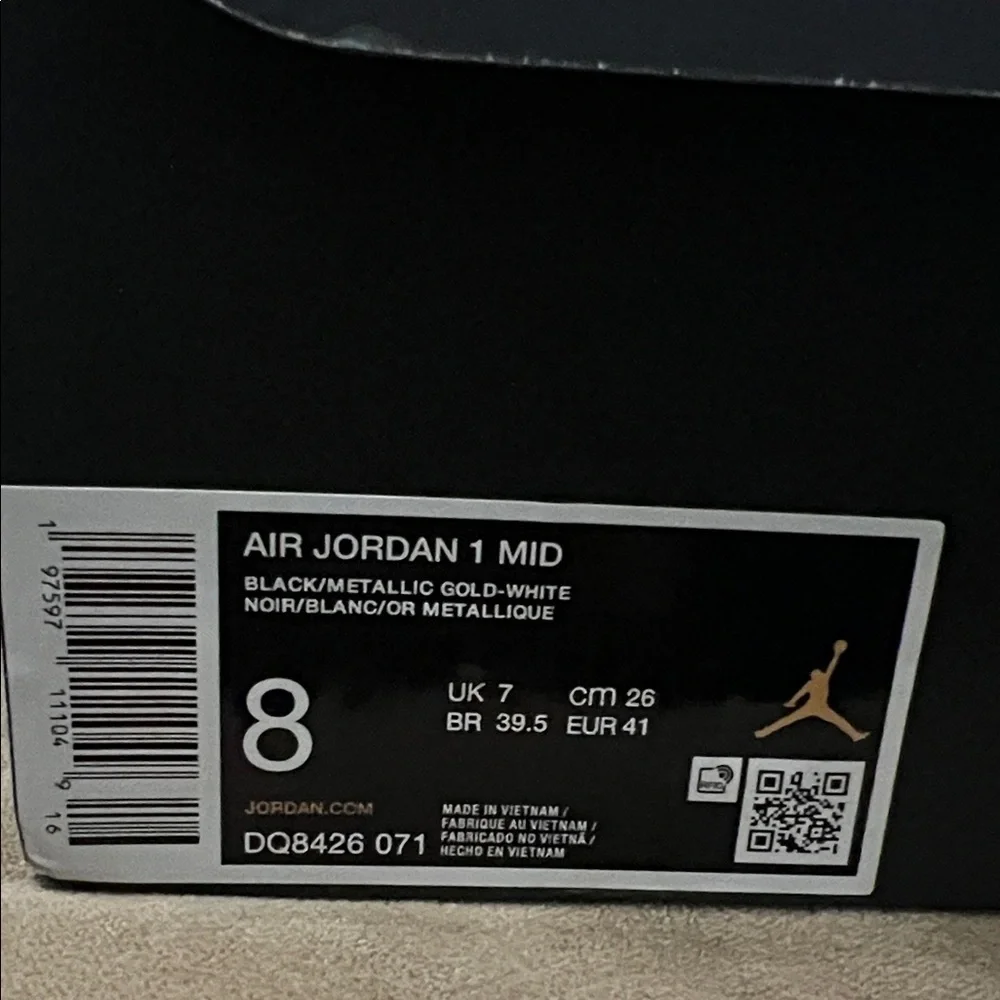 Nike Air Jordan 1 Mid in the black, metallic gold, and white colorway